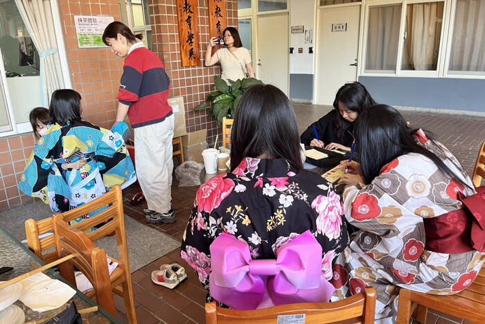 師生穿著浴衣認真書寫結緣繪馬，串連過去、現在與未來圖片