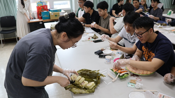 學位生學姐協助幫忙切開越南粽子圖片